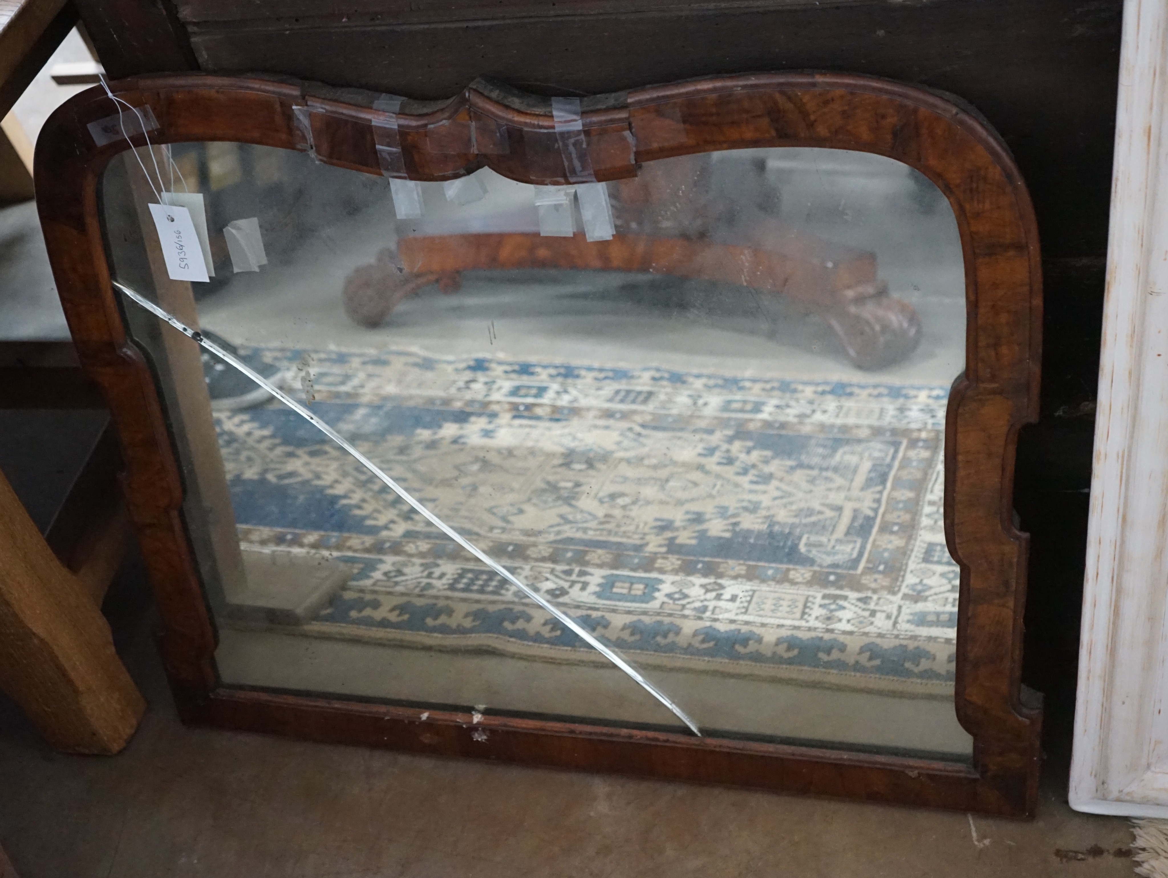 A walnut cartouche shaped wall mirror, with cracked plate, (a.f), width 79cm, height 68cm